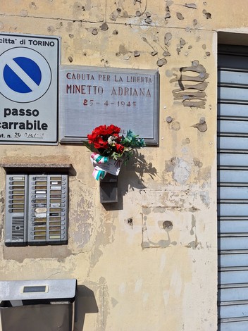 Lapide commemorativa dedicata a Minetto Adriana, caduta per la libertà il 25 aprile 1945. Decorata con fiori.