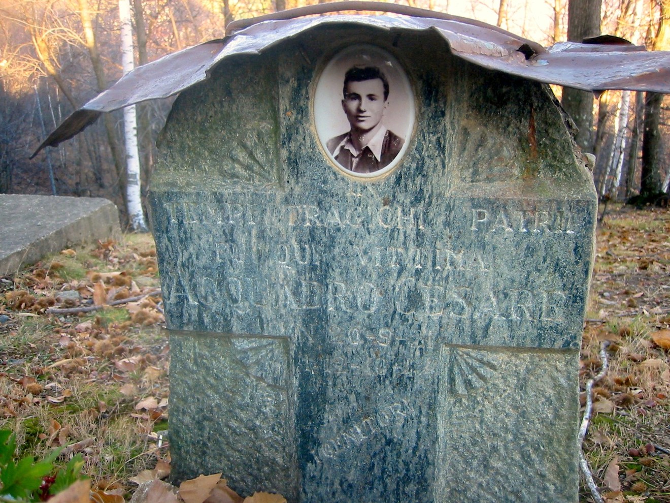 Cippo commemorativo ad Acquadro, decorato con una fotografia e incisi in memoria di un individuo.