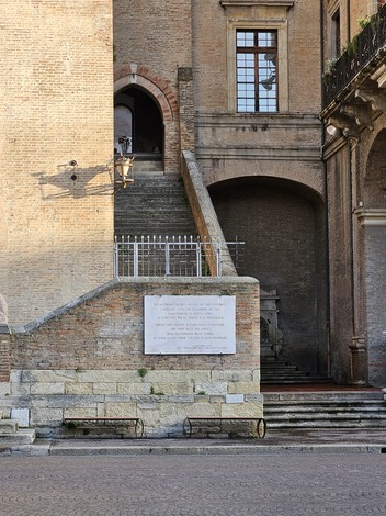 Lapide commemorativa dedicata ai soldati alleati e ai partigiani, situata in un contesto architettonico storico.