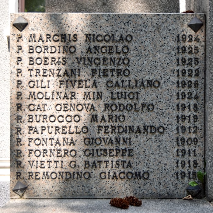 Lapide in pietra con lungo elenco di nomi e date, decorata agli angoli con piccole formelle a losanga.