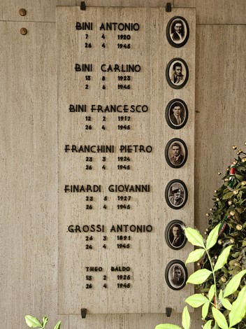 Monumento commemorativo dedicato ai caduti della Resistenza, con nomi e fotografie incastonati nella pietra.