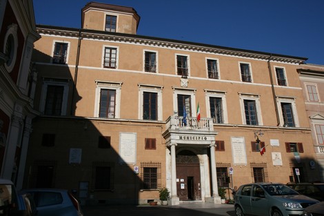 Facciata del Municipio con lapidi commemorative, evidenziando l'importanza storica del luogo.