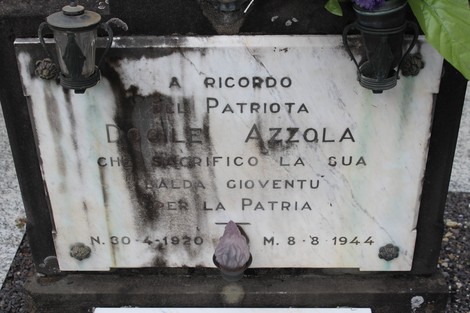 Cippo commemorativo dedicato a Doglio Azzola, eroe patriota, con lanterne e decorazioni.