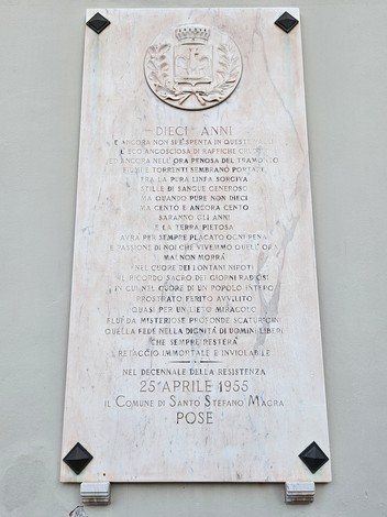 Lapide commemorativa del decennale, con decorazioni e simboli, situata a Santo Stefano Macra.