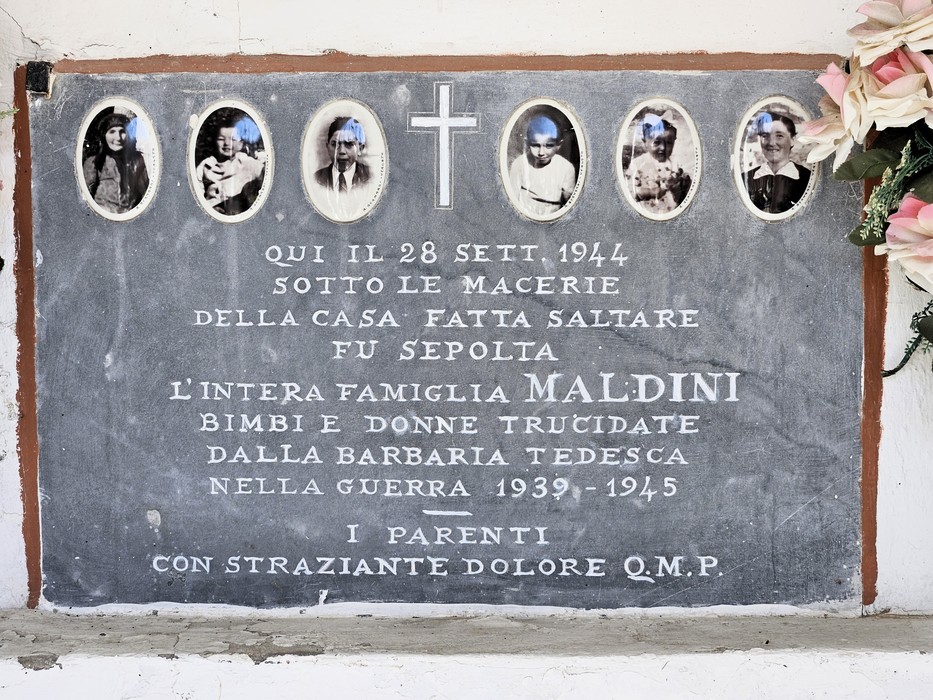 Lapide in pietra con sei fototessere ovali e una croce, iscrizione dedicata alla famiglia Maldini.