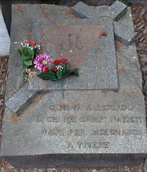 Monumento commemorativo ai deportati, con fiori e simboli, per ricordare le vittime dei campi nazisti.