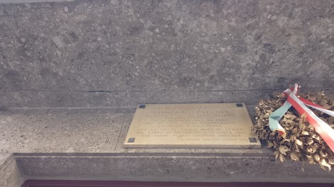 Lapide commemorativa dedicata ai Puecher, con decorazione floreale e simboli patriottici.