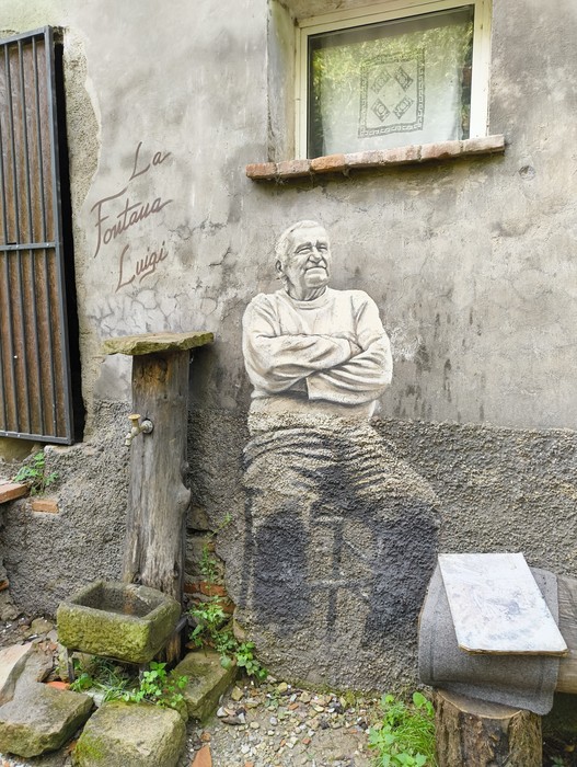 Murale che ritrae un uomo seduto, simbolo della tradizione e della cultura locale.