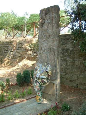 Monumento commemorativo con sculture e fiori, dedito a Cotoneschi e Calcinai, immerso nel verde.