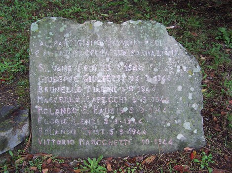 Monumento a Fedi e compagni, in memoria dei caduti, con nomi incisi su una pietra. Atmosfera di rispetto.