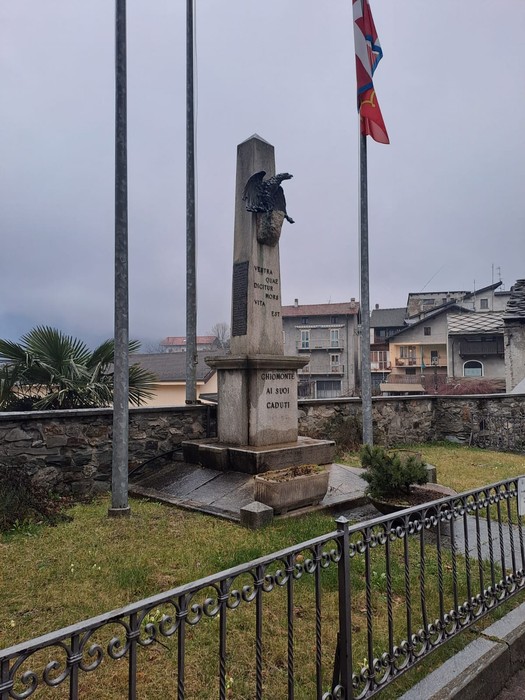 Monumento ai caduti di Chiomonte, commemorazione delle vittime, con bandiere e giardini circostanti.