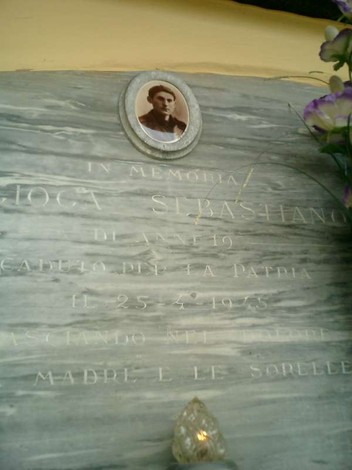 Sepolcro di Gioga con un'immagine e iscrizioni in memoria di un soldato, decorato con fiori.