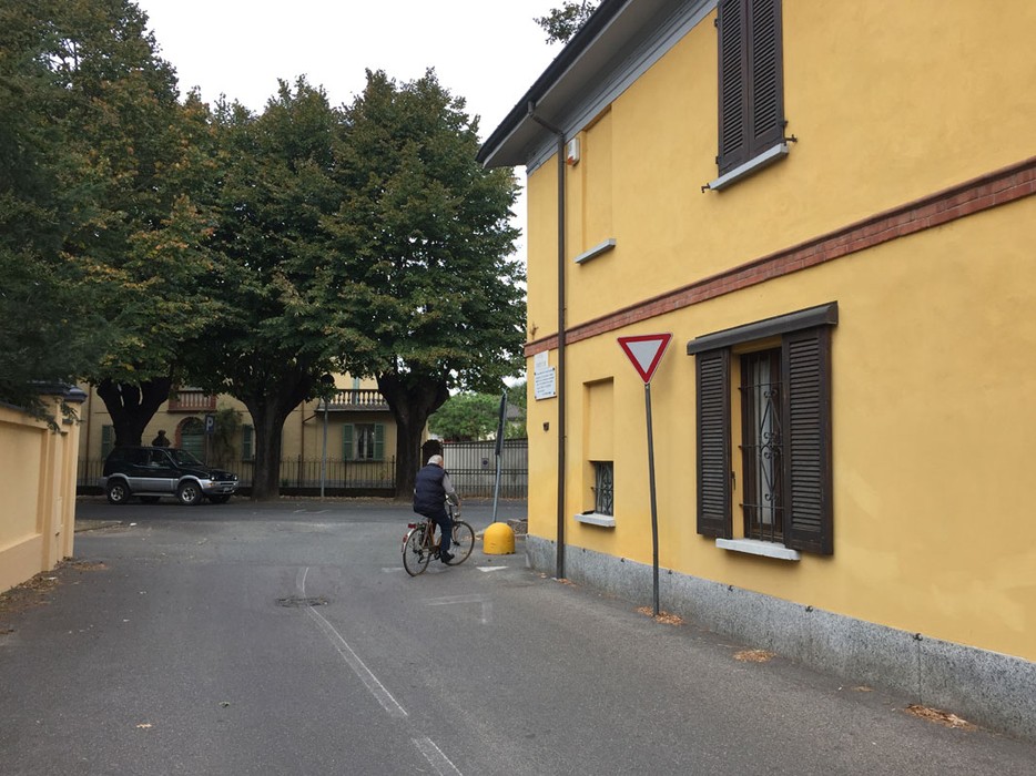 Immagine di una strada con un angolo che evidenzia una lapide dedicata alla famiglia Sacerdote.