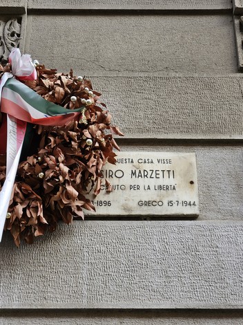 Lapide commemorativa di Ciro Marzetti, con corona di alloro e nastri tricolori, dedicata alla libertà.