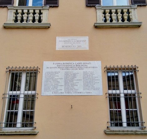 Lapide commemorativa dedicata agli sminatori caduti, situata in una parete di edificio a Bologna.