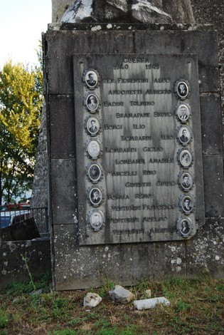 Monumento ai caduti con targhe commemorative e ritratti in onore dei combattenti scomparsi.