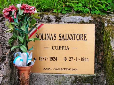 Targa commemorativa dedicata a Salvatore Solinas, con fiori e simboli di onore e memoria.