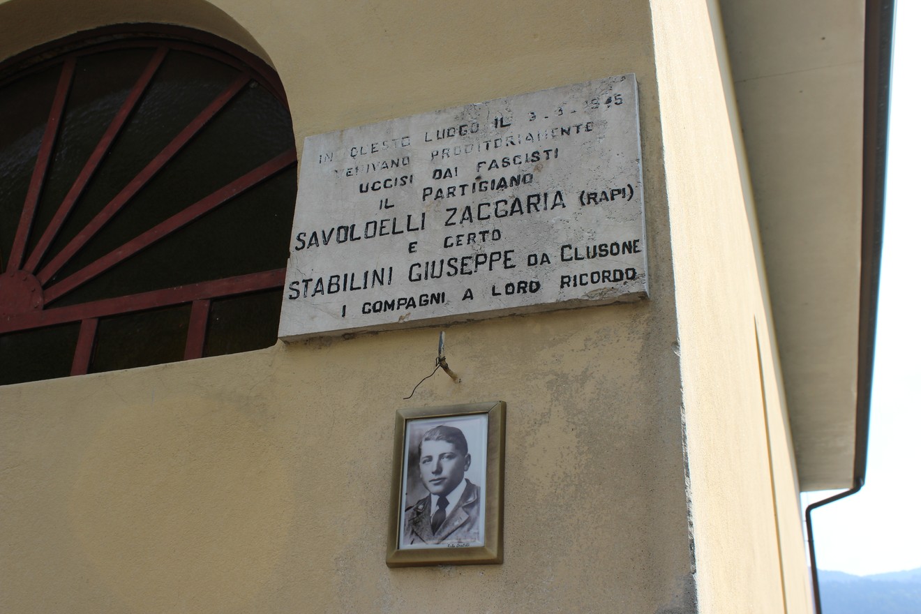 Lapide commemorativa dedicata a Savoldelli Zaccaria e Stabilini Giuseppe, con foto e iscrizioni storiche.