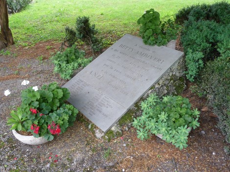 Lapide commemorativa ad Ambiveri dedicata ai partigiani di Seriate, circondata da piante e fiori.