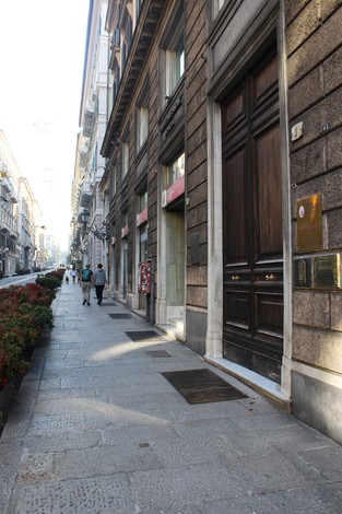 Pietra d'inciampo in una strada di Labò, con edificio e marciapiede in un contesto urbano.