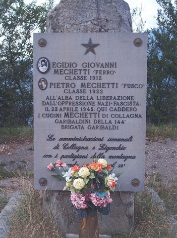 Cippo commemorativo dedicato ai Mechetti, eroi della Resistenza, con omaggio floreale ai loro sacrifici.