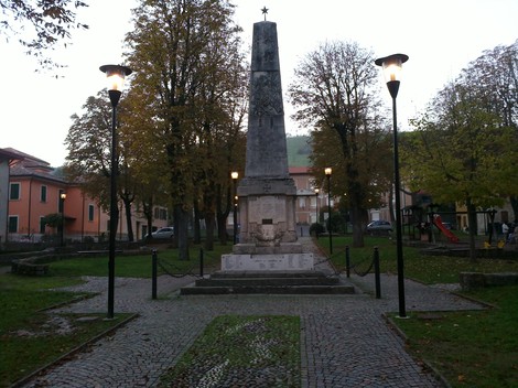 Monumento ai Caduti di Vezzano, dedicato ai sacrifici dei soldati locali, circondato da un verde parco pubblico.