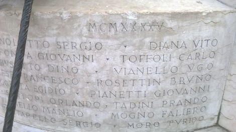Monumento ai caduti dei Carmini con nomi incisi su lastre di pietra. Atmosfera solenne e commemorativa.