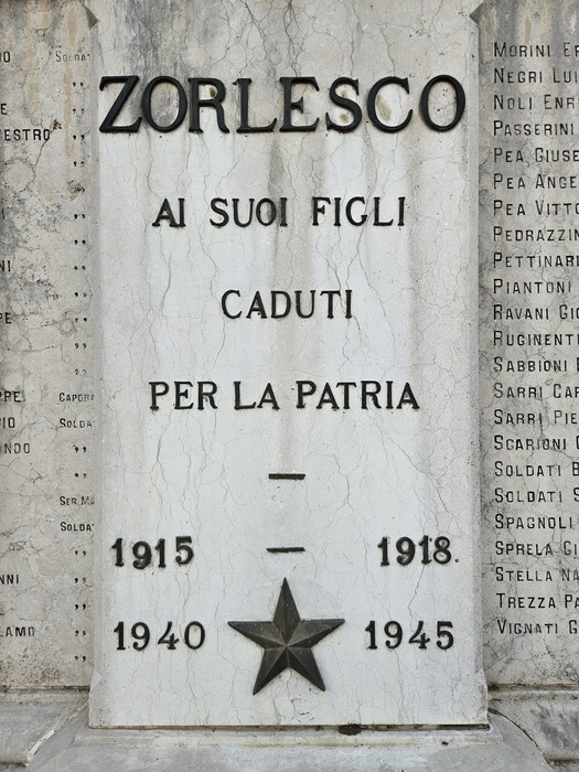 Lapide in marmo con iscrizione e stella a rilievo, inserita in una parete esterna.