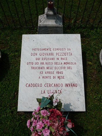 Lapide commemorativa in marmo dedicata a otto soldati russi, con fiori e iscrizioni ricordando il loro sacrificio.