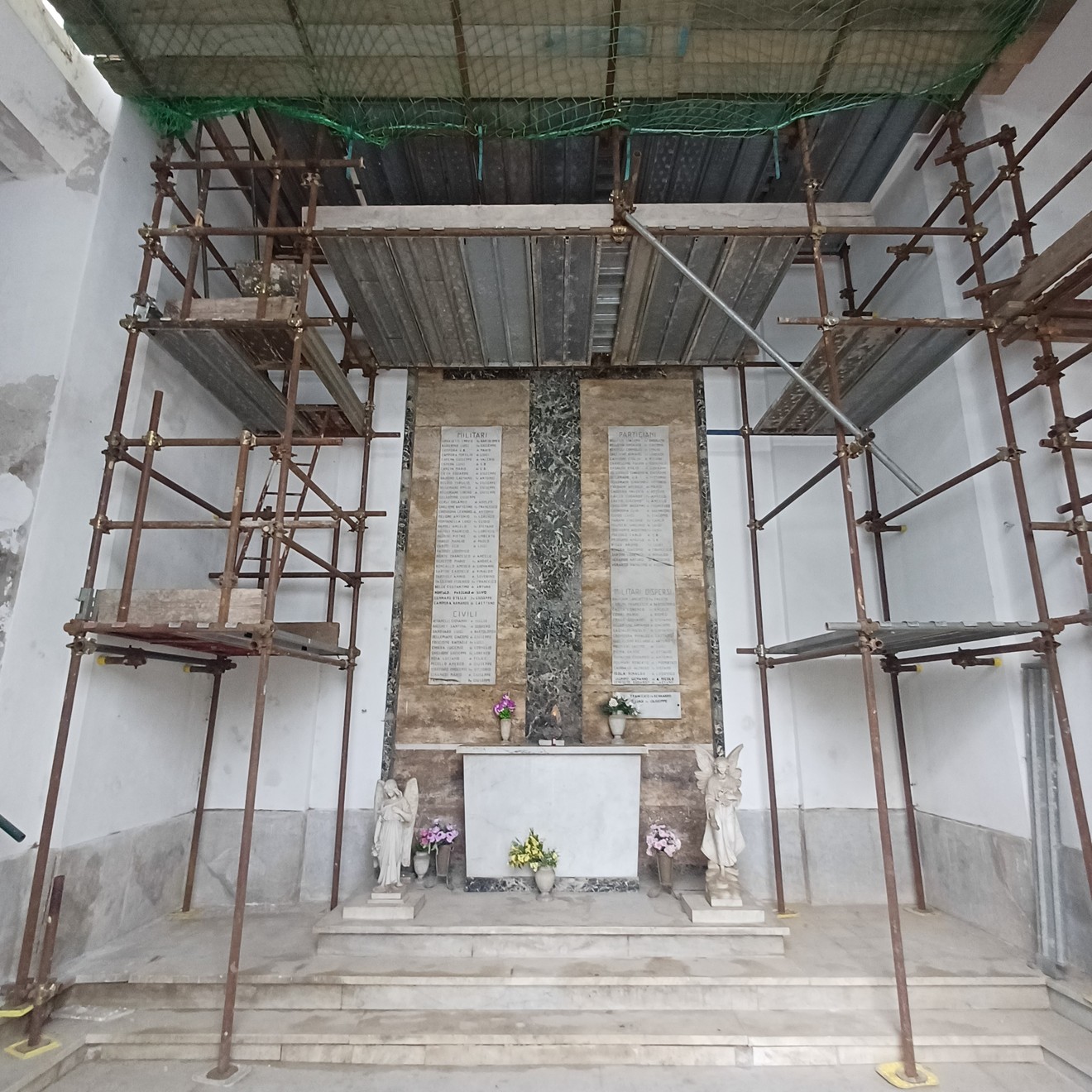 Cappella con altare e due lapidi marmoree a parete, impalcature in corso di restauro.