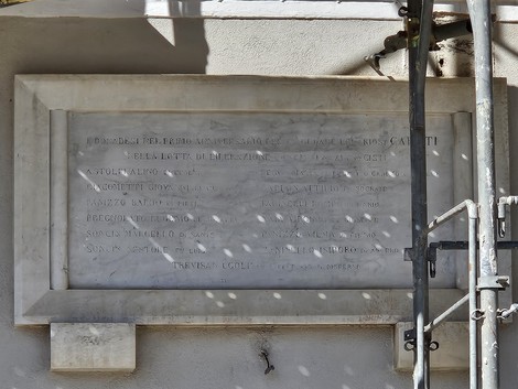 Lapide commemorativa dedicata ai caduti nella lotta di liberazione, incastonata in un muro.