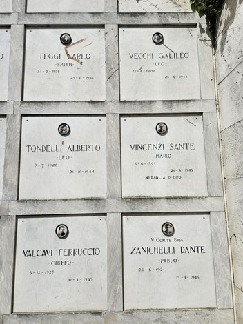 Monumento ai Caduti Partigiani con lapidi commemorative e fotografie di eroi della Resistenza.