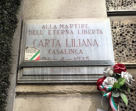 Lapide commemorativa dedicata a Carta Liliana, martire per la libertà, con dati storici e omaggio floreale.
