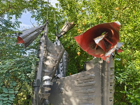 Monumento astratto dedicato a Bartolini, Pizzoli, Zuppiroli e Albertini, immerso nella natura.