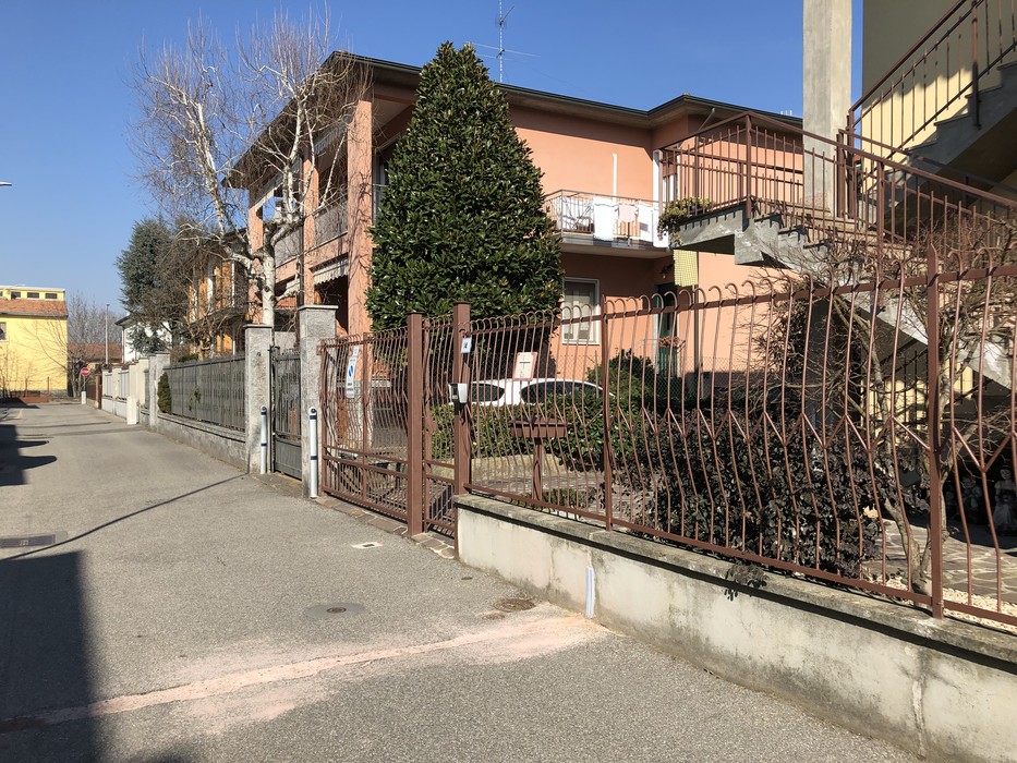 Immagine di un'area residenziale con una pietra d'inciampo in memoria di una persona.