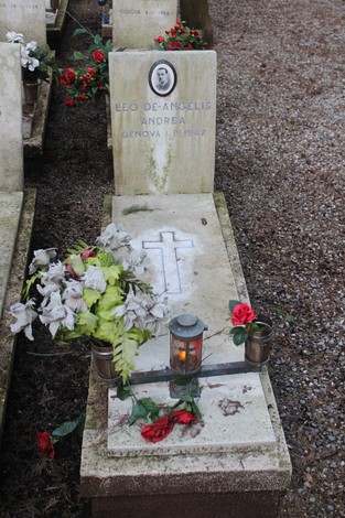 Tombe decorate con fiori e candele nel cimitero, dedicate ai caduti per la libertà.