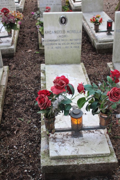 Tombe decorate con fiori, illuminazione e lapidi in memoria dei caduti per la libertà.