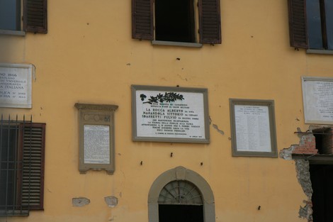 Lapide commemorativa sul municipio, dedicata a eventi storici locali. Mura con affreschi e documenti storici.