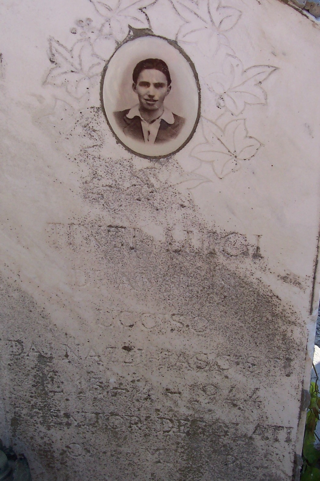 Sepolcro di Tinti, con ritratto e iscrizione commemorativa su marmo, in un contesto funerario.