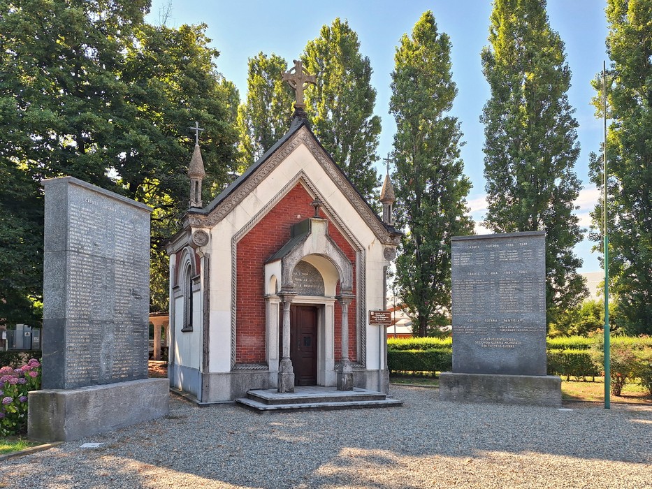 Monumento ai caduti con piccola cappella adornata da colonne e due stele commemorative ai lati.