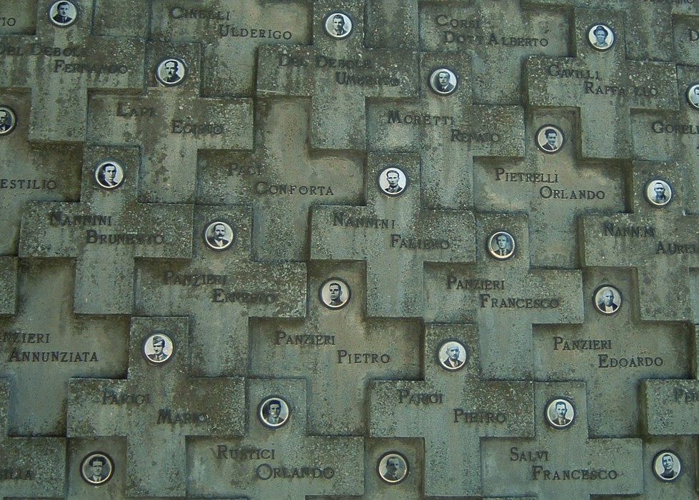 Monumento commemorativo nel cimitero di San Pancrazio con foto e nomi di commemorazione.