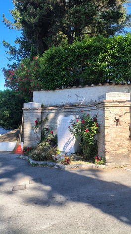 Lapide commemorativa in un'area verde, contornata da piante e fiori, dedicata ai martiri de La Storta.