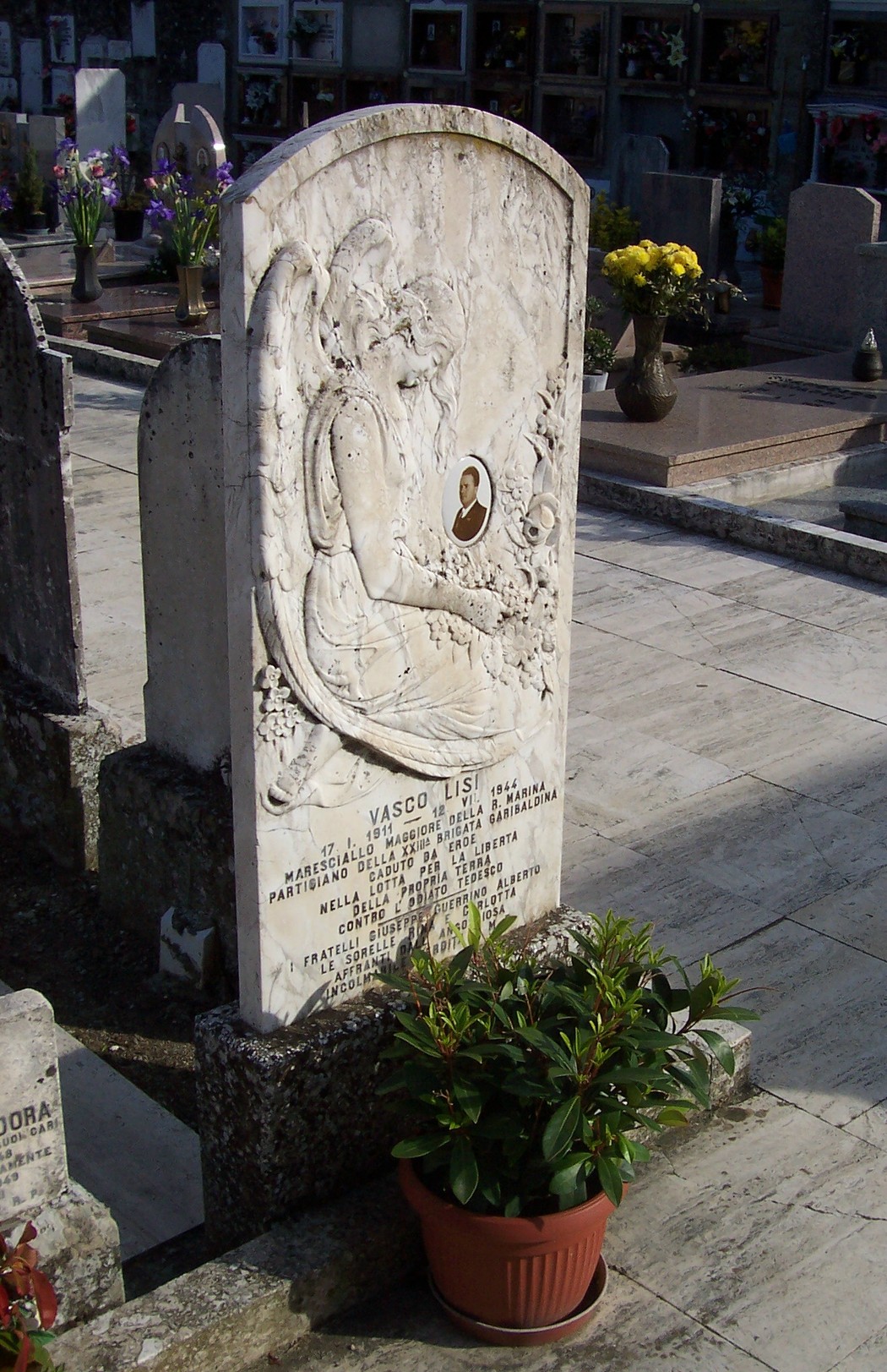 Sepolcro di Lisi, una tomba decorata con un’immagine e ornamenti floreali, situata in un cimitero.