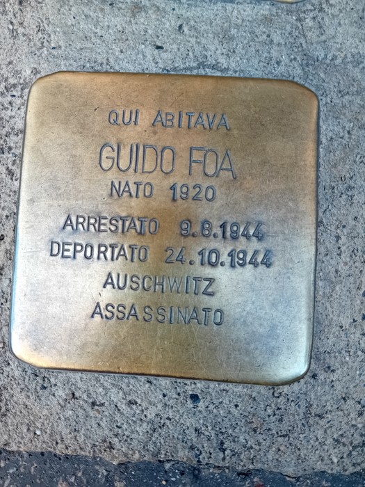 Pietra d'inciampo in ottone incastonata nel marciapiede, con iscrizione dedicata a Guido Foa.
