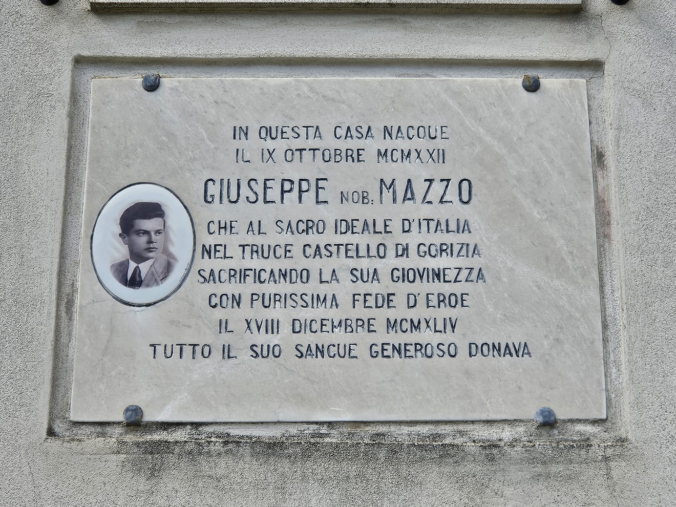 Lapide commemorativa di Giuseppe Mazzo, con dettagli sulla sua vita e il sacrificio durante la giovinezza.