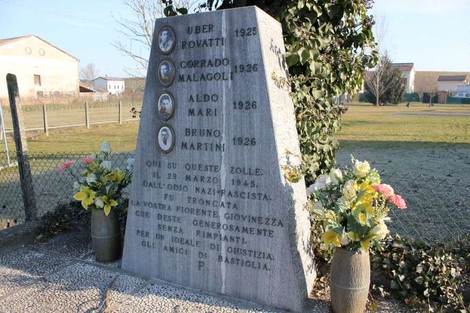 Cippo commemorativo dedicato a Rovatti, Malagoli, Mari e Martini, con fiori e iscrizioni, in un'area verde.