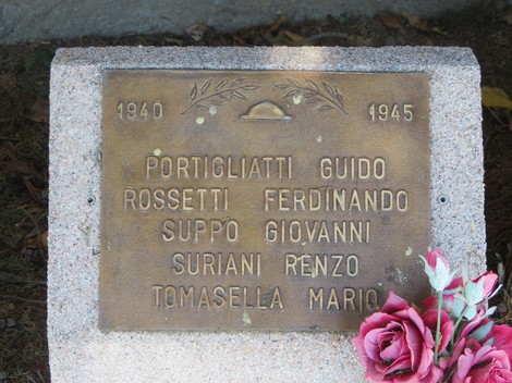 Cippi commemorativi che onorano i caduti tra il 1940 e il 1945, con decorazioni floreali.