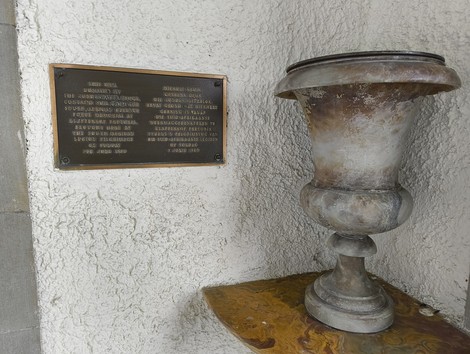 Urna commemorativa nel cimitero di guerra sudafricano, simbolo di ricordo e onore ai caduti.