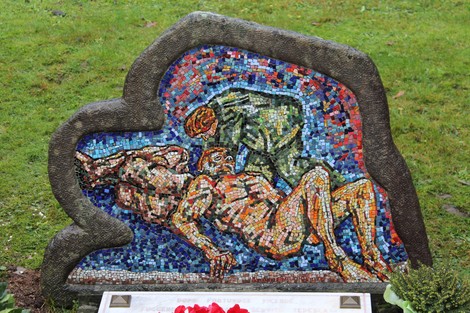 Monumento ai caduti partigiani russi, con mosaico raffigurante figure umane in un contesto commemorativo.