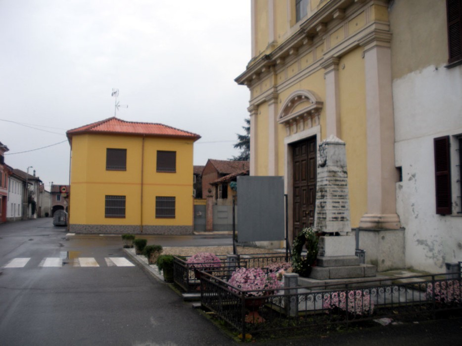 Monumento ai caduti di Cornale, situato in un'area tranquilla vicino a edifici storici e fioriere.